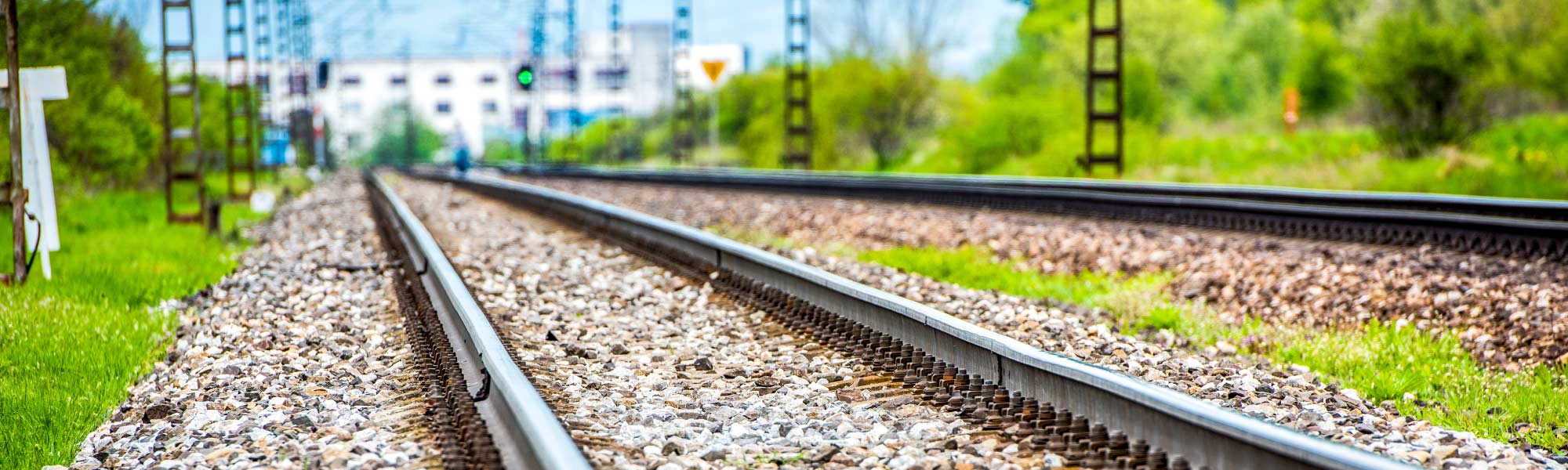 a close up picture of a railway line, green trees in the background