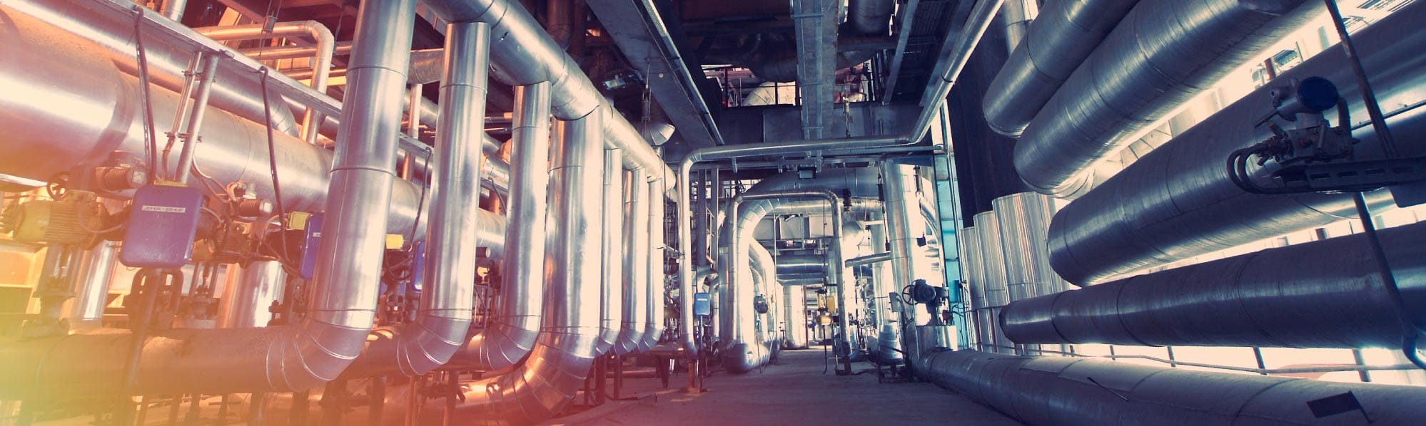 A picture of shiny large pipes within a factory
