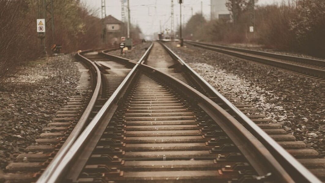 Sepia-toned image of a railway line stretching into the distance, fading out of view.