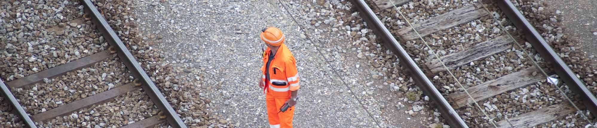 Rail worker view from above, stood in between 2 railway tracks