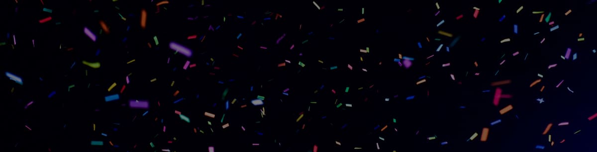 Colourful confetti falling against a black background.