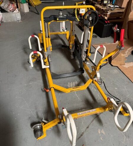 Yellow electric hand grinder frame used by rail contractors in a workshop.