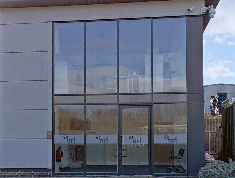Modern office building with large glass windows showing NRL branding at the entrance.